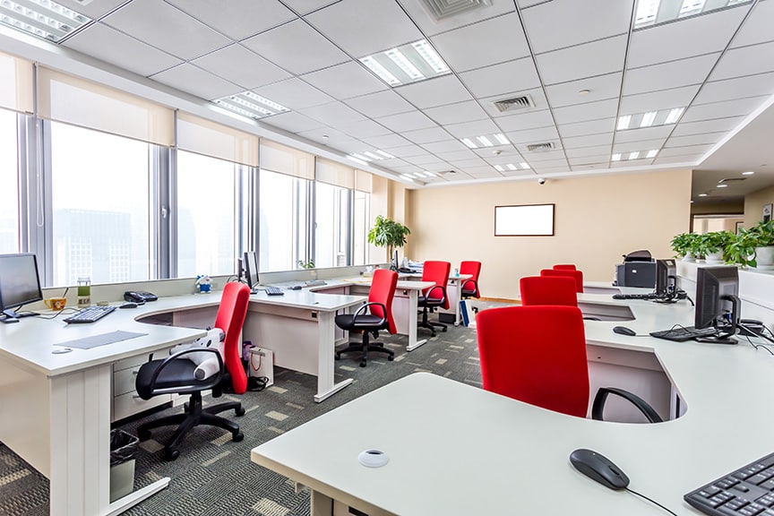 empty modern office space with white desks and red chairs